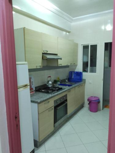 a kitchen with a sink and a stove top oven at Appartement de vacances in Agadir