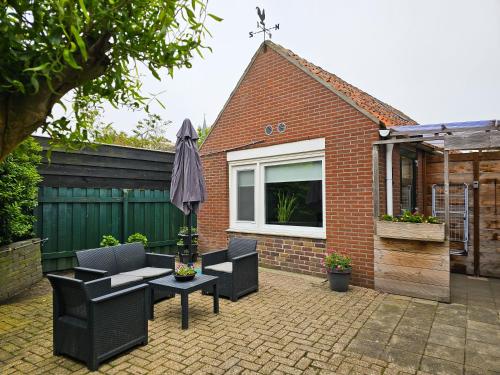 a patio with a table and chairs and an umbrella at Vakantiehuis Gapinge GA03 met omheind terras in Gapinge