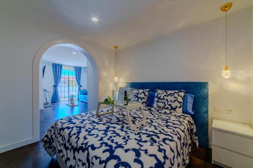 a bedroom with a bed with a blue and white comforter at Villa in south of Tenerife in Costa Del Silencio