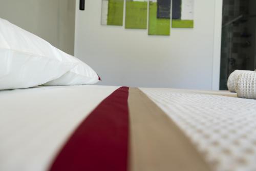 a bed with a red and white quilt on it at Green Land Boutique Hotel in Castilenti