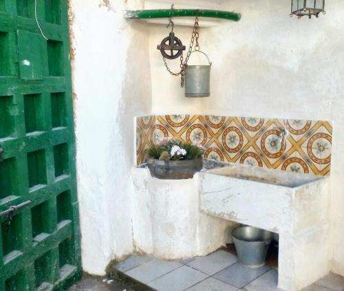 un fregadero de piedra en una pared con una maceta en 3 bedrooms house with enclosed garden and wifi at El Poyo del Cid, en El Poyo