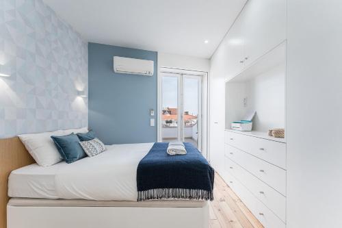 um quarto com uma cama com uma parede azul em GuestReady - The Other Side no Porto