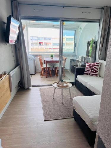 un salon avec un canapé et une table dans l'établissement Le Dauphin - 150m de la plage - Piscine -, à La Grande Motte