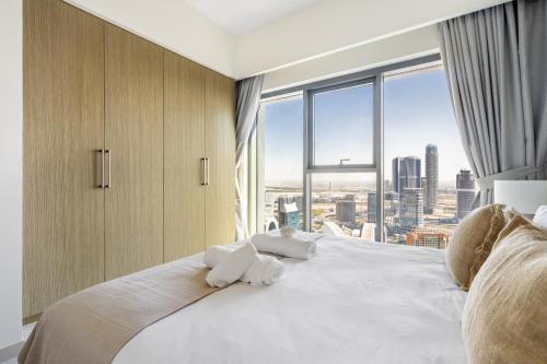 een slaapkamer met een groot wit bed en een groot raam bij The Downtown Dubai Collection in Dubai