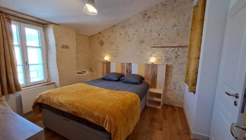 a bedroom with a bed with blue pillows on it at CANTETEAU - Agreable maison chaleureuse et conviviale in La Chaume