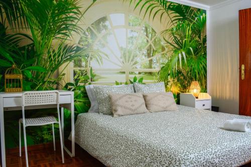 a bedroom with a bed and a desk and plants at Live Oporto Rooms in Porto