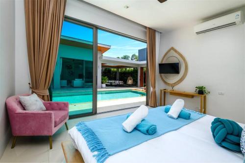 a bedroom with a large bed and a swimming pool at Villa Mimosa 1, Splendid 4 Bedroom Master Ensuite in Phuket Town