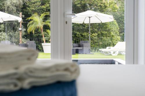 a view of a patio with an umbrella and a pool at Villa Stay Luxury Property Ponte De Lima in Ponte de Lima
