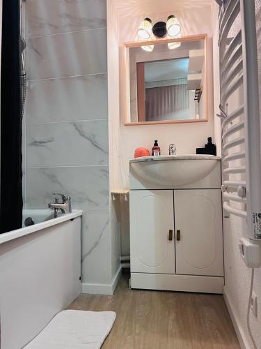 une salle de bain avec un lavabo et un miroir dans l'établissement Le Dauphin - 150m de la plage - Piscine -, à La Grande Motte