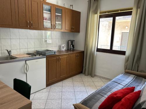 una pequeña cocina con cama y lavabo en 4 Sisters Apartments, en Gradac