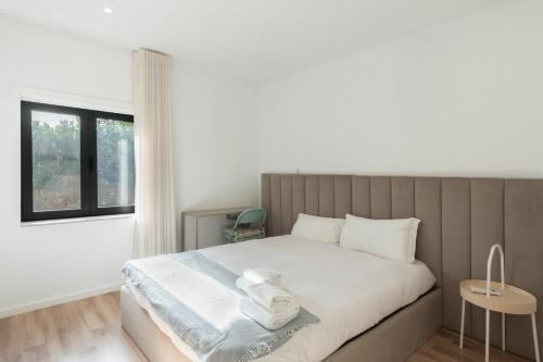 1 dormitorio con 1 cama con sábanas blancas y ventana en GuestReady - Valbom Douro View, en Valbom