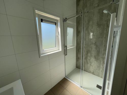 a bathroom with a shower and a window at Camping de Vogel in Hengstdijk