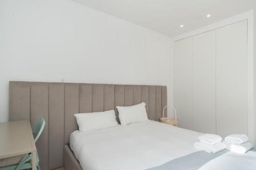 1 dormitorio con 1 cama blanca grande y escritorio en GuestReady - Valbom Douro View, en Valbom