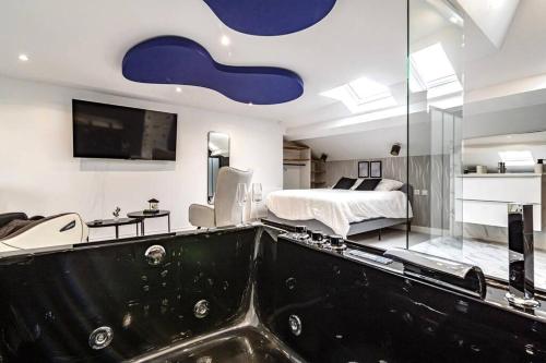 La salle de bains est pourvue d'une grande baignoire. dans l'établissement Loft Évasion luxe Jacuzzi, à Reims