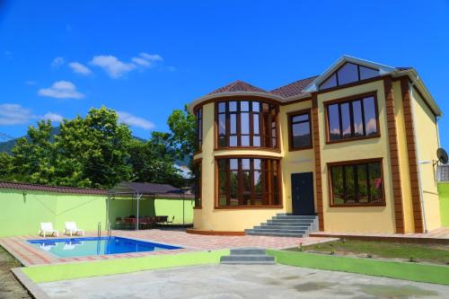 a house with a swimming pool in front of it at Panorama of the Mountains in Gabala