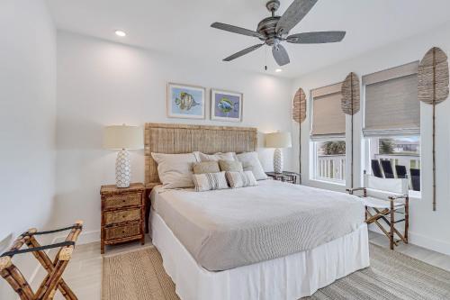 a white bedroom with a bed and a ceiling fan at Casa De Coconuts in Padre Island