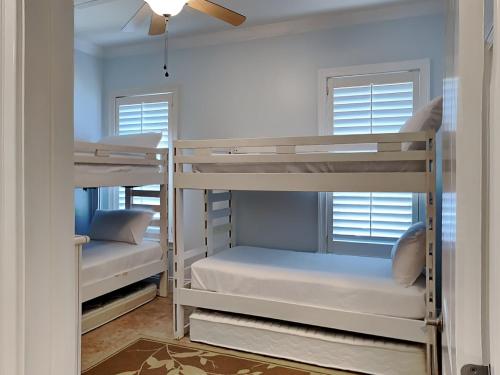 two bunk beds in a room with two windows at Adagio 101f in Santa Rosa Beach