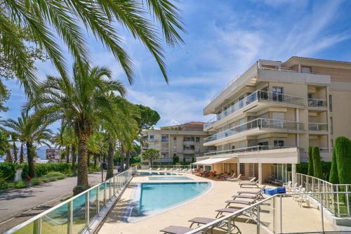 un hôtel avec une piscine et un bâtiment dans l'établissement Superbe appart Cannes bord de plage avec piscine, à Cannes