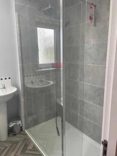 uma casa de banho com um chuveiro e um lavatório. em 41 Larchwood Drive Holiday Home em Inverness