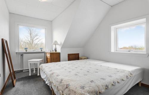 a white bedroom with a bed and two windows at Cozy Home In Brovst With House Sea View in Brovst