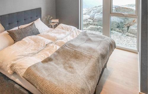 Bett in einem Zimmer mit Fenster in der Unterkunft Cozy Home In Stabbestad With House Sea View in Stabbestad