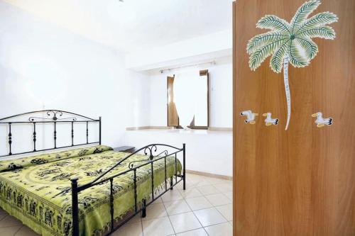 a bedroom with a bed with a palm tree sticker on the door at One bedroom house with shared pool enclosed garden and wifi at Vibo Valentia in Parghelia