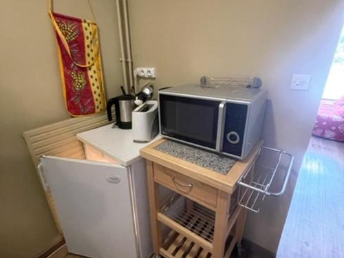 un micro-ondes posé sur un petit bureau dans l'établissement Appart 2 pièces au pied des pistes, balcon, 6 pers, Les Adrets - FR-1-557-105, à Les Adrets