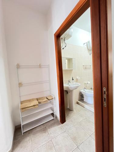 a bathroom with a sink and a toilet and a mirror at Appartamenti Pina in Vieste