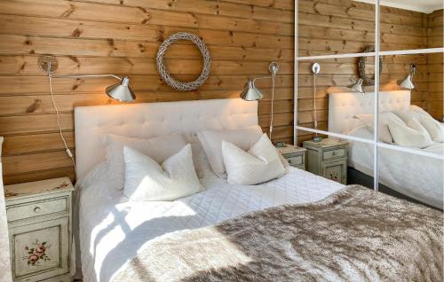 a bedroom with a white bed and wooden walls at Lovely Home In Stryn With House A Panoramic View in Stryn