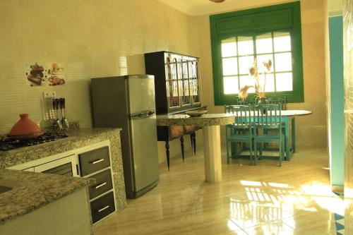 Tamraght Ou FellaにあるTamraght 3 Bedroom Apt with Oceanview 2.Levelの冷蔵庫と椅子付きのテーブルがあるキッチン