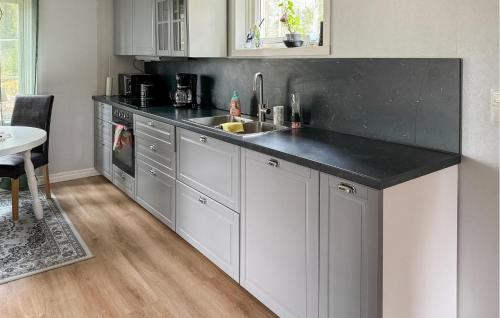 Una cocina con gabinetes blancos y una encimera negra. en Cozy Home In Åmål With Wifi, en Åmål