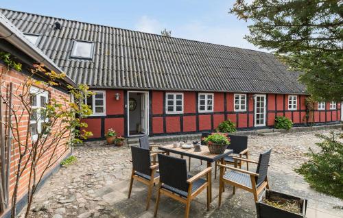 a table and chairs in front of a red house at 2 Bedroom Beautiful Apartment In Kolind in Kolind