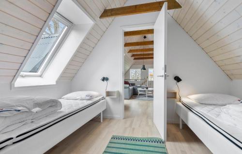 una camera mansardata con due letti e una finestra di 2 Bedroom Beautiful Apartment In Kolind a Kolind