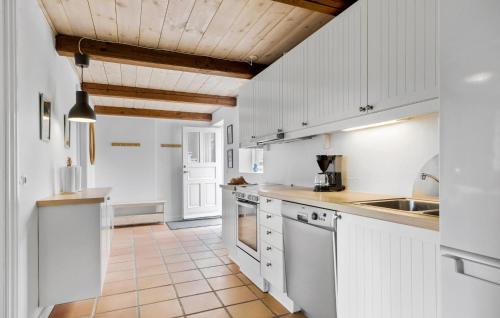 a kitchen with white cabinets and a tile floor at 2 Bedroom Beautiful Apartment In Kolind in Kolind