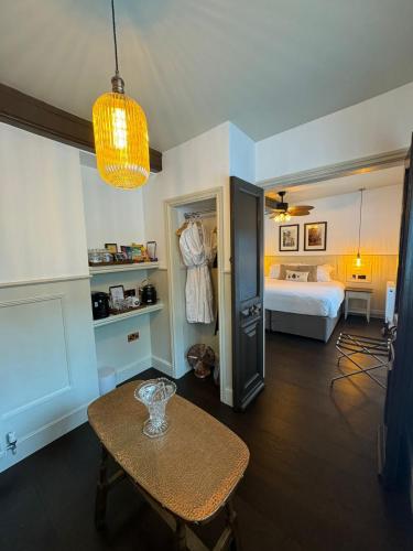 a room with a table and a bedroom with a bed at Woolpack Inn in Canterbury