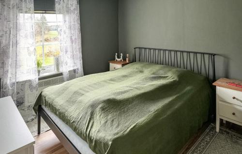 a bedroom with a green bed with a window at Beautiful Home In ml With Kitchen in Åmål