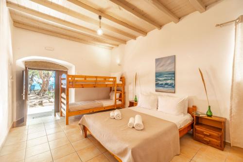 een slaapkamer met 2 bedden en een stapelbed bij Mylos Seaside Experience in Frangokastello