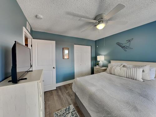聖彼得海灘的住宿－Madeira Beach Yacht Club 343h，一间卧室设有蓝色的墙壁和一张带吊扇的床。