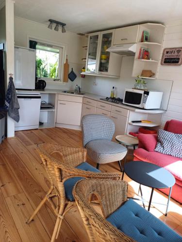 a kitchen with wicker chairs and a table in a room at Vrije Vogels tuin met privacy in Warmenhuizen