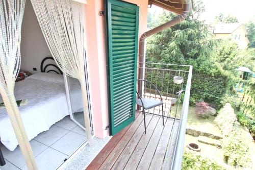 a porch with a green door and a bed on a balcony at B&B Località Manzoniane in Lecco