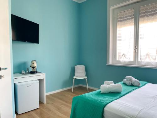 a blue bedroom with a bed and a chair at B&B LIBRA rooms & suite in Salerno