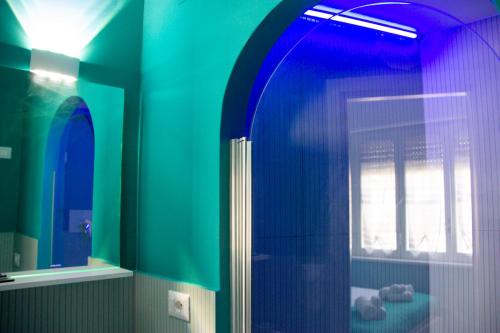 a blue bathroom with a shower and a window at B&B LIBRA rooms & suite in Salerno
