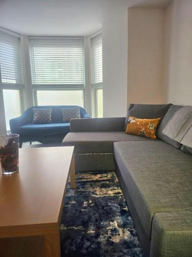 a living room with a couch and a table at Seaside Haven Coastal Comfort 200m from the Beach in Kent