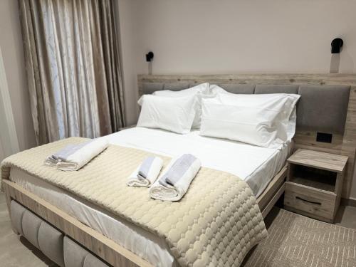 a bedroom with a bed with two towels on it at Hotel Kseal in Përmet