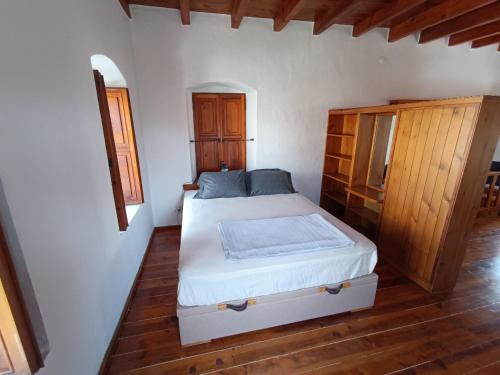 1 dormitorio con 1 cama y suelo de madera en Stone House, en Bodrum City