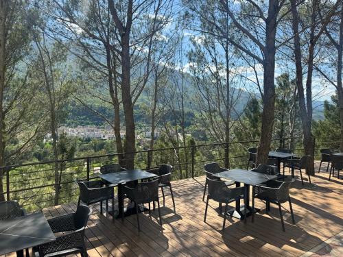 a patio with tables and chairs on a deck at Hotel Kseal in Përmet