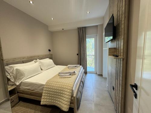 a bedroom with a bed and a flat screen tv at Hotel Kseal in Përmet