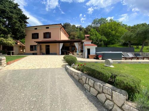 ein Haus mit einer Steinmauer und einer Auffahrt in der Unterkunft Holiday Home Vintage in Supetarska Draga