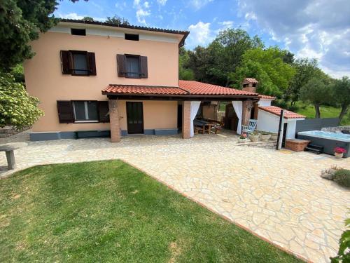a house with a patio and a swimming pool at Holiday Home Vintage in Supetarska Draga
