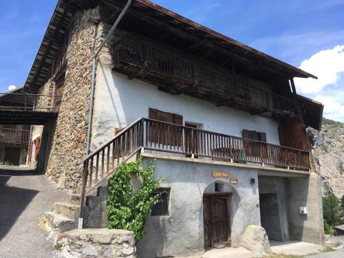 un bâtiment avec un balcon sur le côté dans l'établissement Jas des Rousses - Champcella, à Champcella